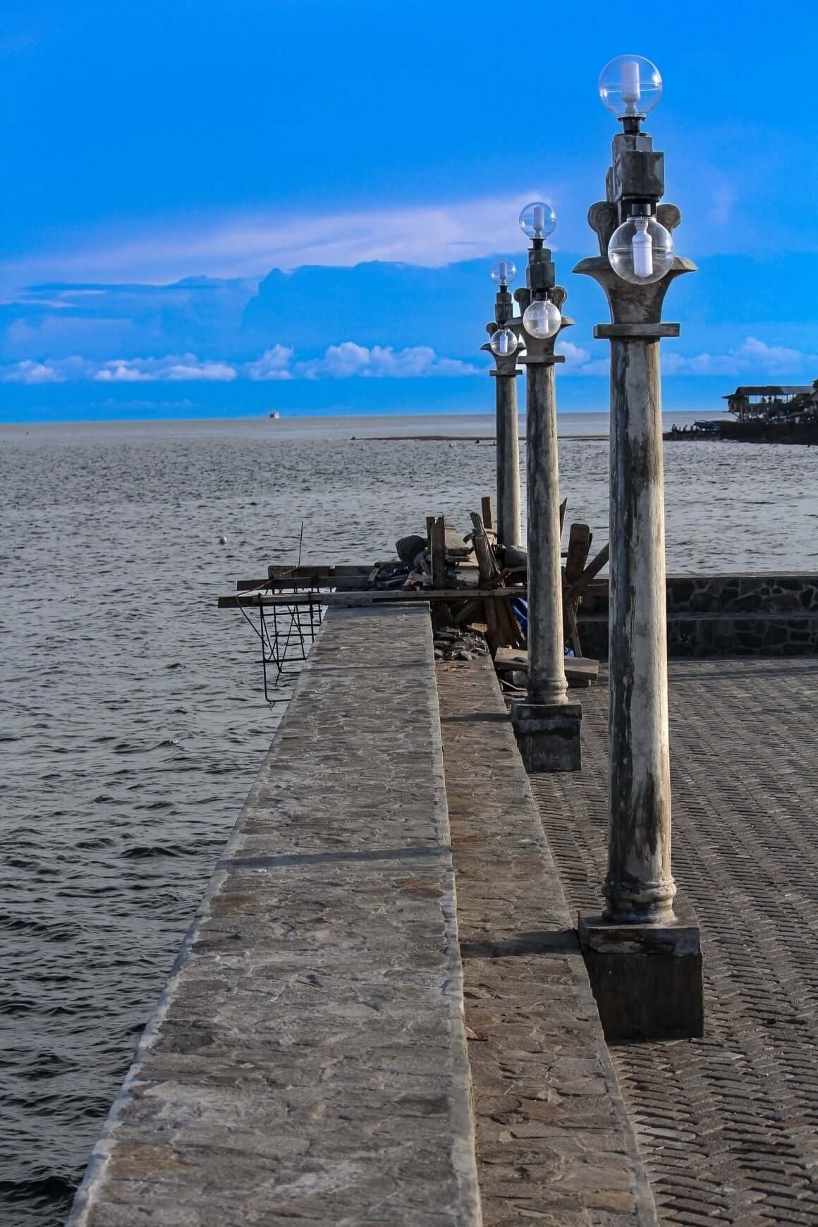 Lamposts of Dumaguete's Rizal Boulevard viewed against the sea.